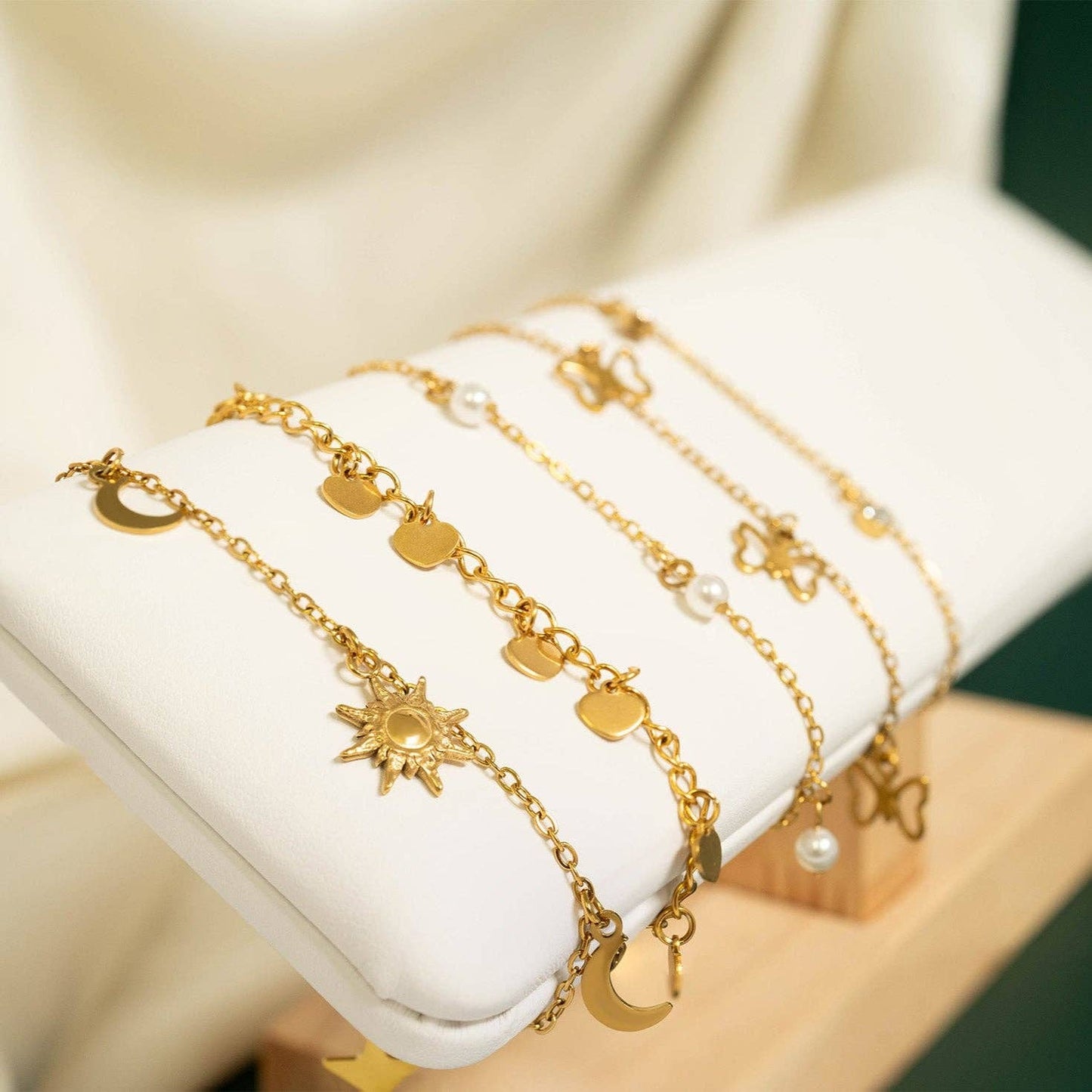 Set of gold bracelets with various charms on a white surface