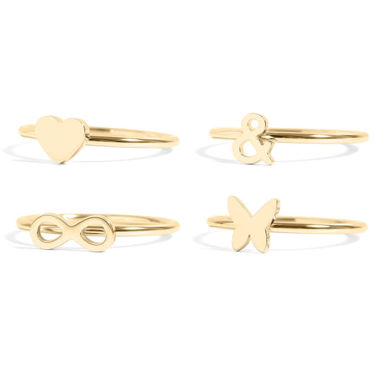 Set of four gold rings with heart, infinity, ampersand, and butterfly designs on a white background.