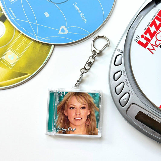 CDs and a keychain with a photo of a woman on a white background