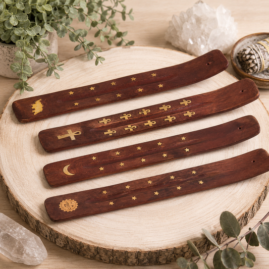 Four dark brown wooden bookmarks with gold celestial and religious symbols, arranged on a round wooden slice with crystals and greenery in the background.