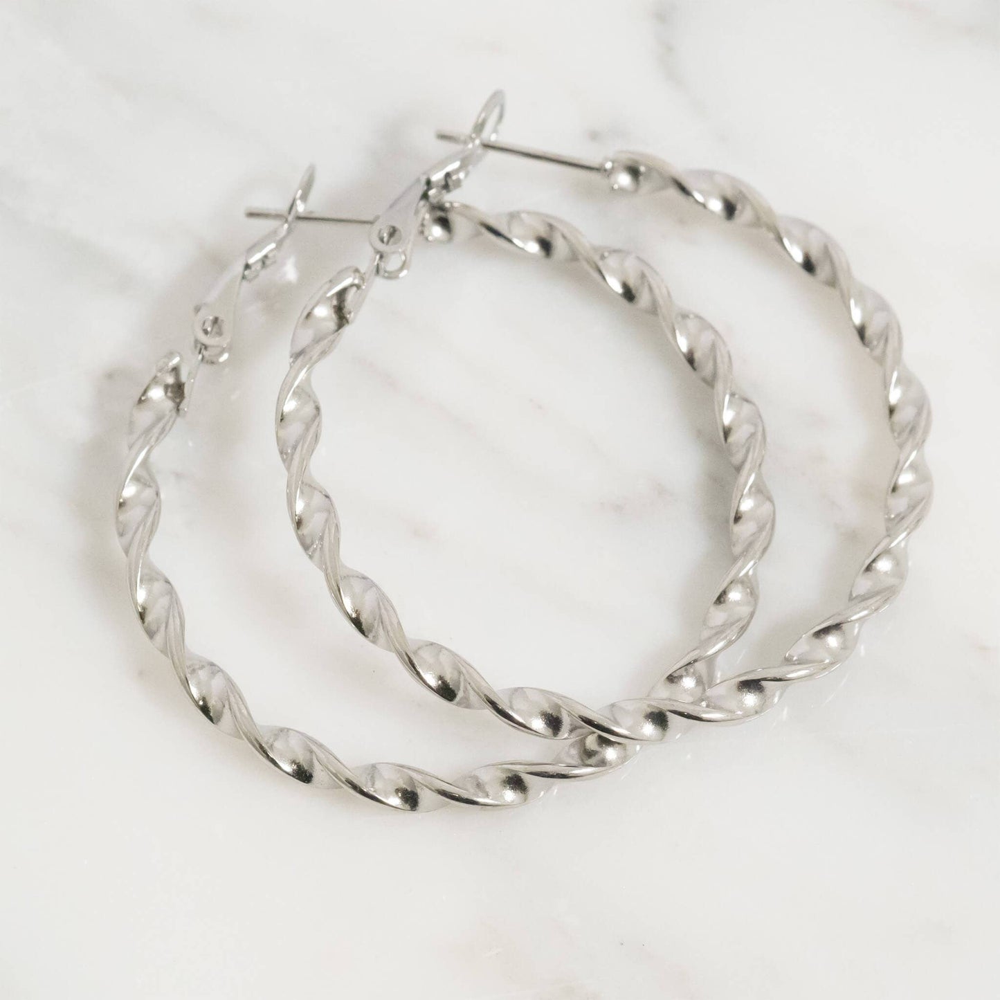 Pair of silver hoop earrings on a white background