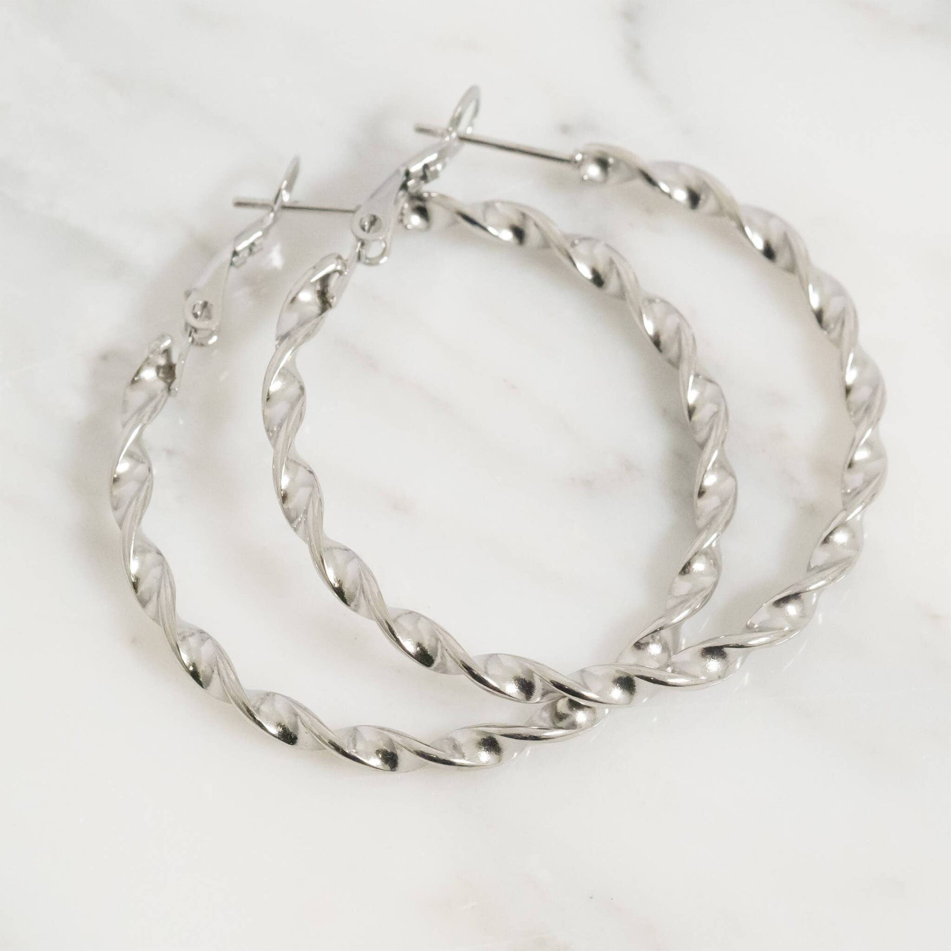 Pair of silver hoop earrings on a white background