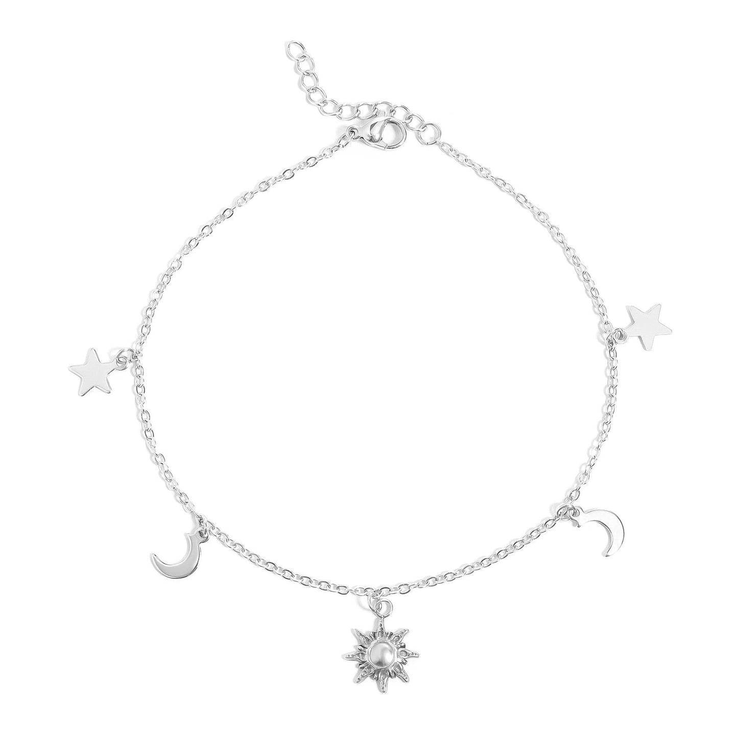A delicate silver chain anklet featuring celestial charms, including a central sun charm with a pearl center, flanked by crescent moons and stars, shown on a plain white background.